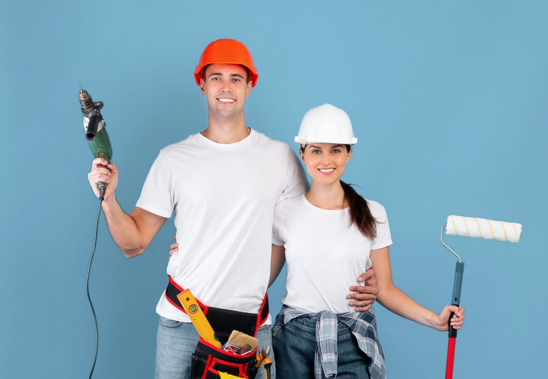 House renovation smiling couple with drill and roller paint brush in hands.jpg