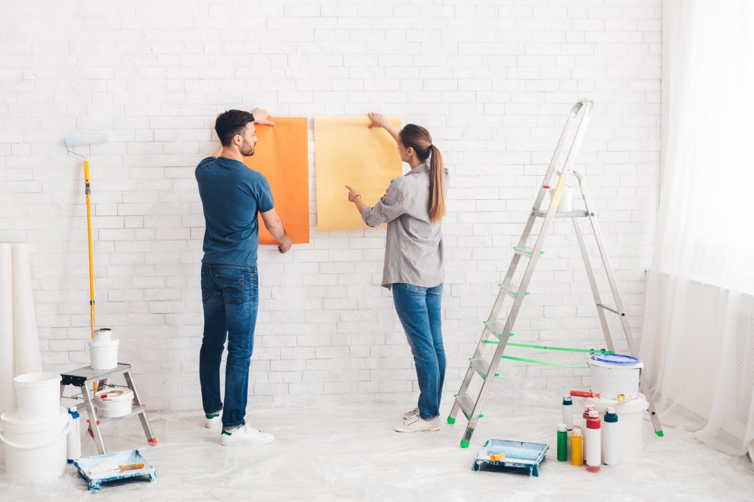 Young happy couple choosing in what color painting their new house.jpg